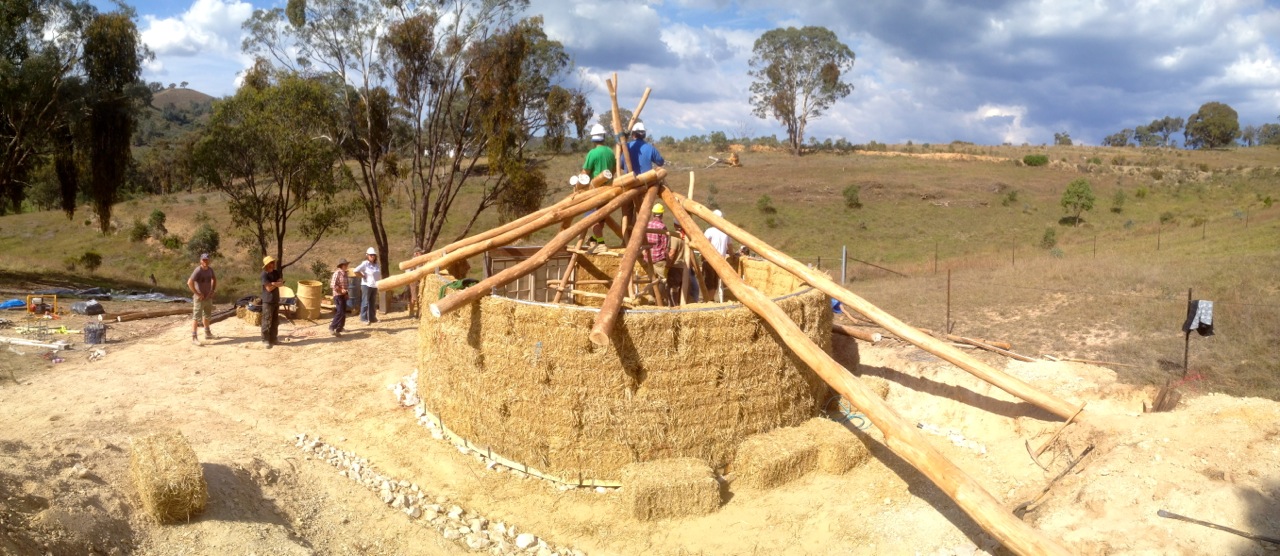 The frame is up! The two extra long beams that come down to ground level are to create a undercover 'lean to' at the back of the building